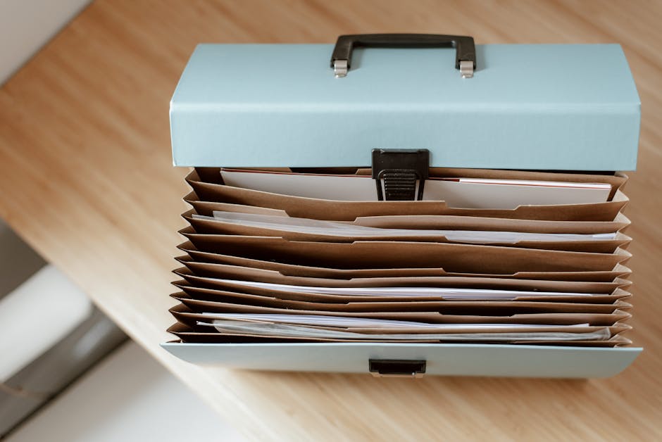 Caixa organizadora de documentos sobre uma mesa de escritório.